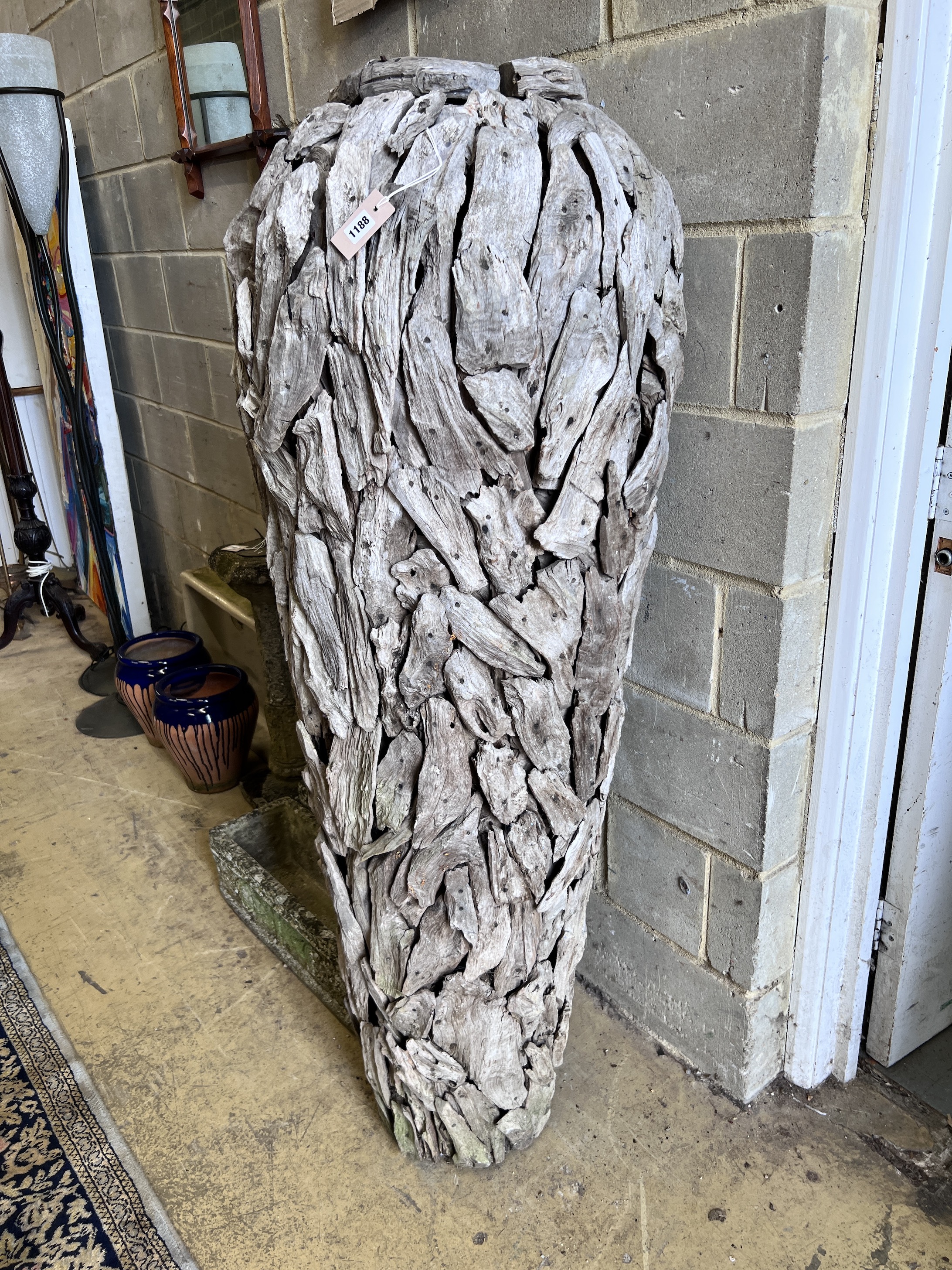 A large driftwood urn shaped garden ornament, height 155cm